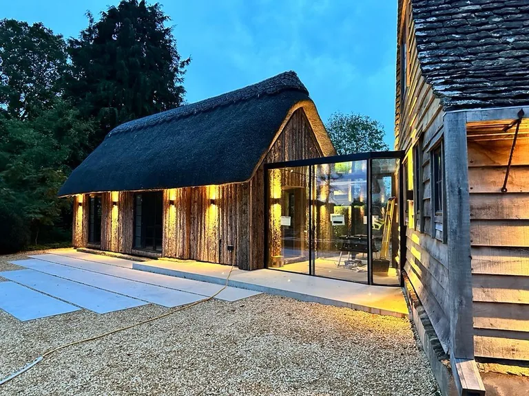 Evening exterior view of timber and stone construction with large glazing