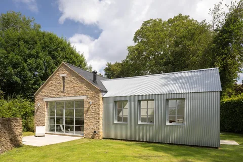 Garden elevation with stone walls, wide glazing and contemporary link room