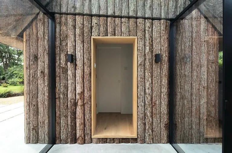 Close-up of timber cladding and a recessed doorway on a completed Gloucestershire project